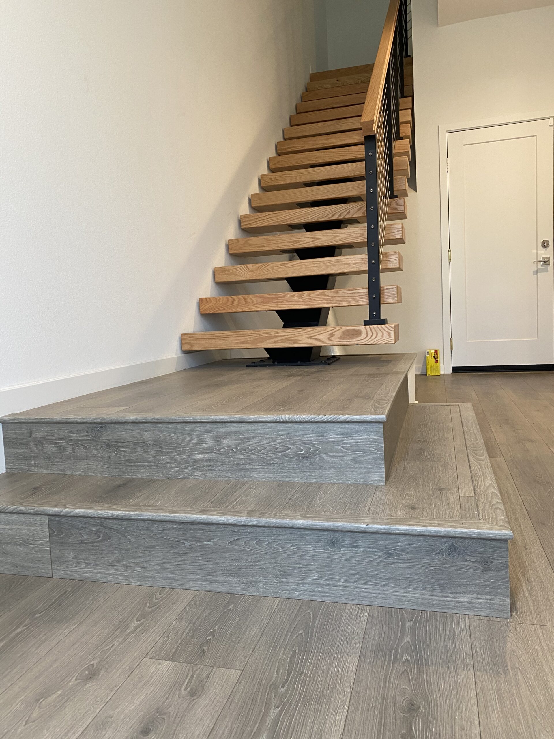 Grey Laminate Floor and Wood Stair Installation.