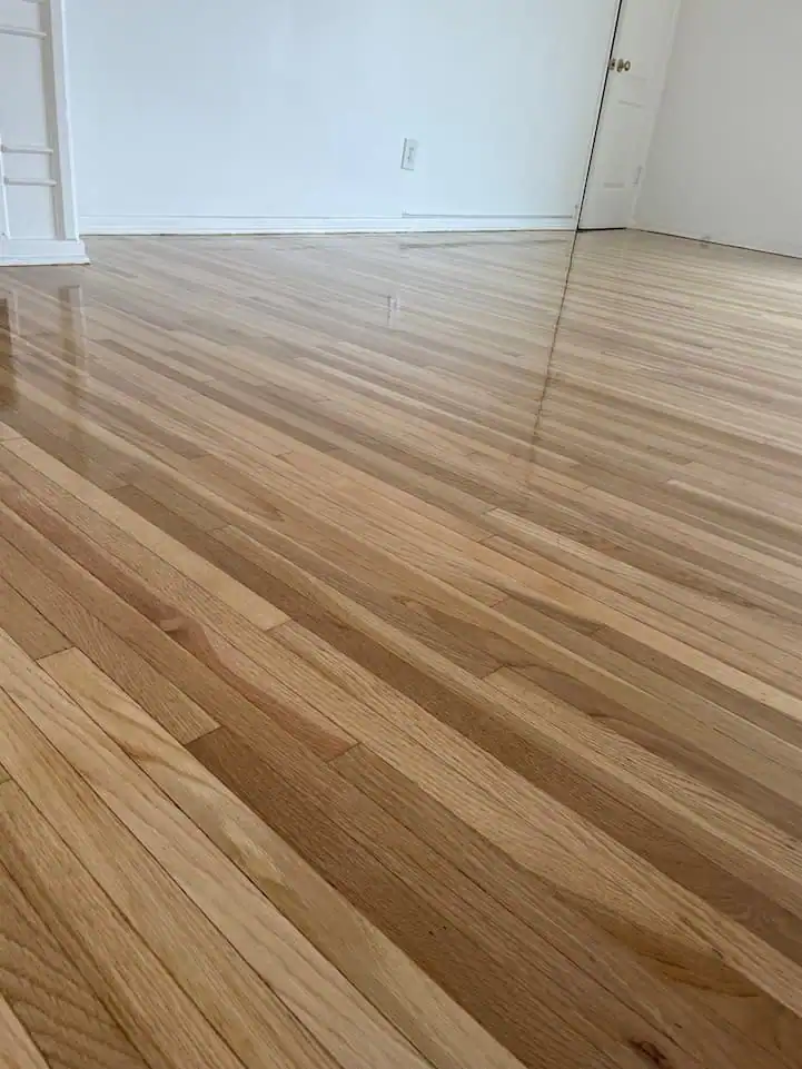 Refinished oak hardwood floor with restored natural color, smooth surface, and enhanced durability after professional sanding and refinishing